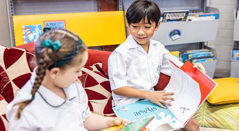 Students smiling and reading at Corpus Christi Catholic Primary School Cranebrook
