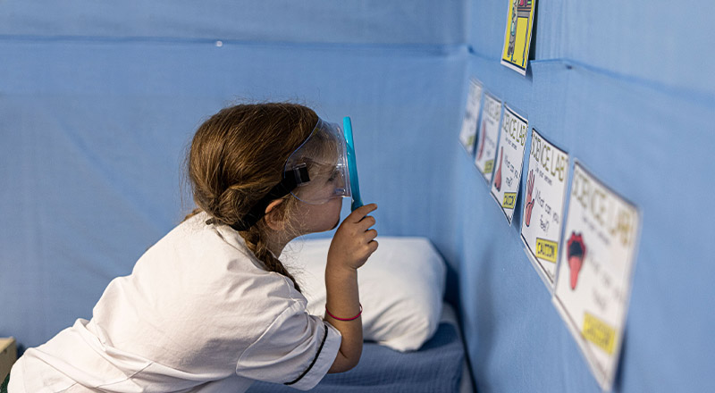Student with magnifying glass at Corpus Christi Catholic Primary School Cranebrook